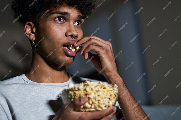 close-up-portrait-young-guy-eating-popcorn-while-watching-movie-home_386185-565-1