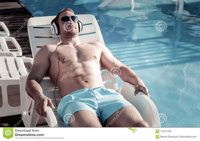 well-built-gentleman-sunbathing-lying-sunbed-favorite-leisure-activity-relaxed-young-man-listening-to-music-playing-112177197